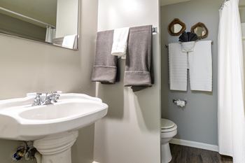 A bathroom with a white sink and toilet.